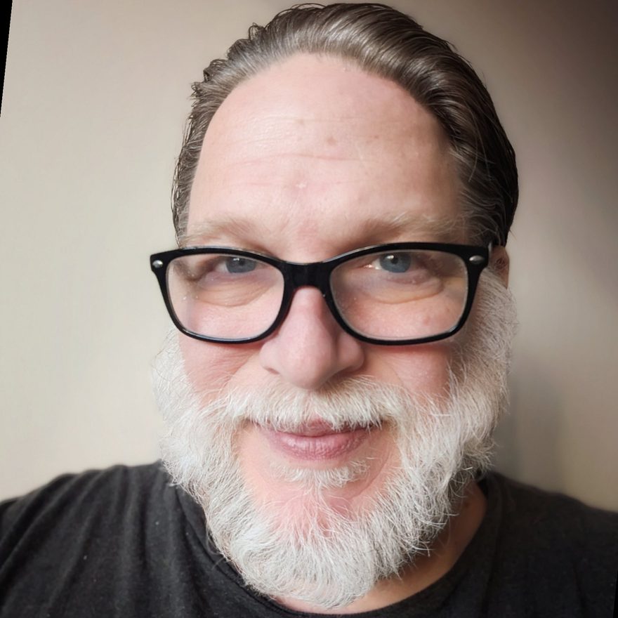 Portrait of Chris Brogan, smiling, with glasses and a white beard